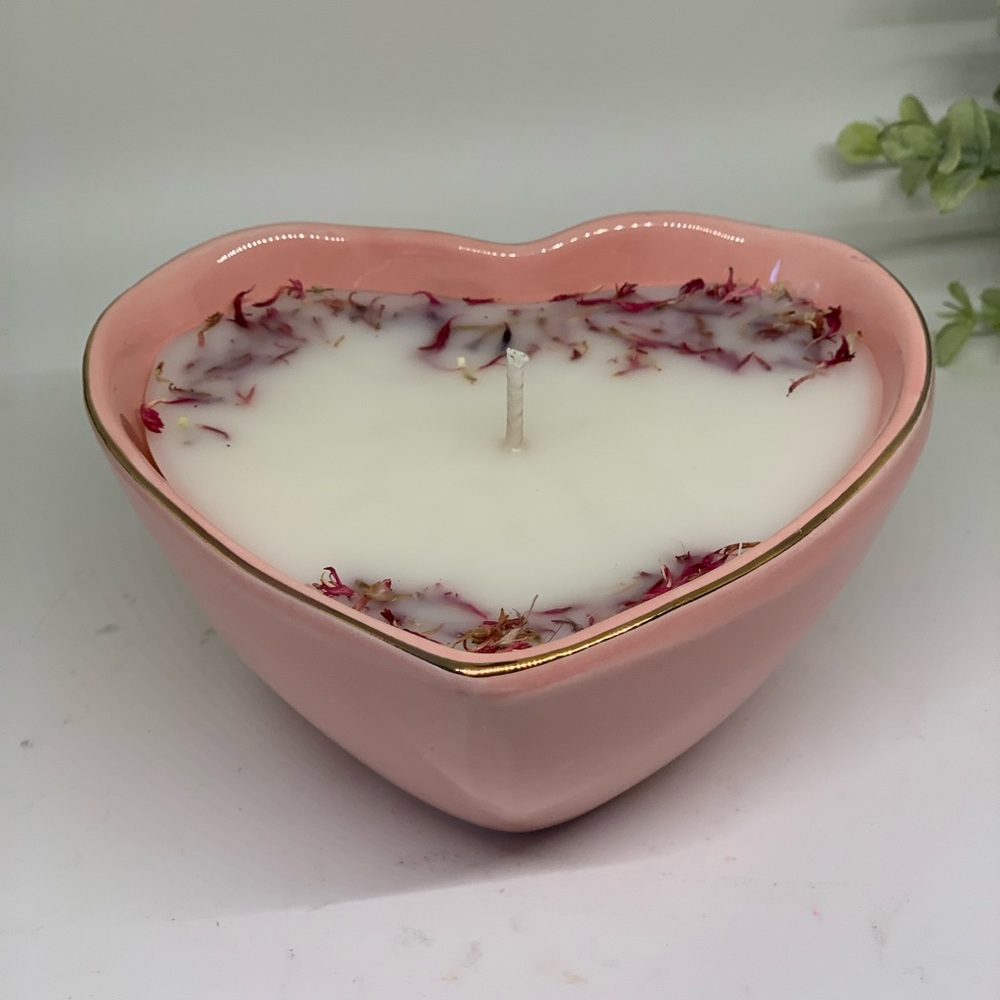 Pink heart shaped candle with gold trim.